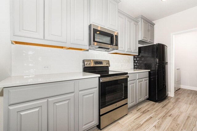 8409 Alba Ln, Rowlett, TX 75089 - kitchen featuring stainless steel appliances, light countertops, decorative backsplash, and light wood-type flooring