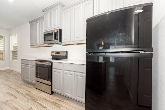 8409 Alba Ln, Rowlett, TX 75089 - kitchen featuring appliances with stainless steel finishes, baseboards, light countertops, and light wood-type flooring