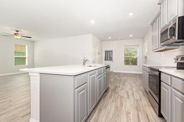 8409 Alba Ln, Rowlett, TX 75089 - kitchen featuring stainless steel appliances, a sink, gray cabinets, baseboards, and recessed lighting
