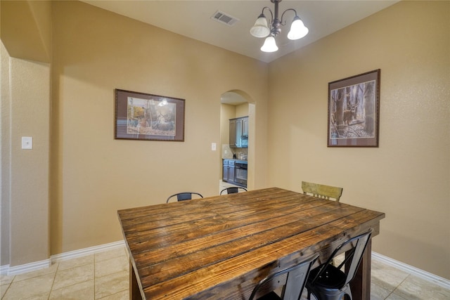 144 Brady Coleman Ln, Springtown, TX 76082 - dining room with arched walkways, light tile patterned floors, a chandelier, and baseboards