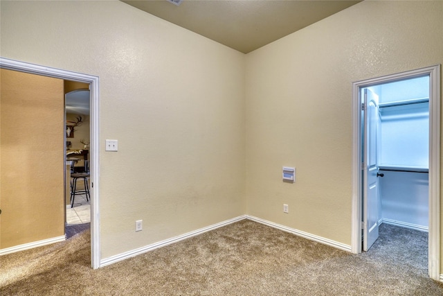 144 Brady Coleman Ln, Springtown, TX 76082 - unfurnished bedroom featuring carpet flooring, a walk in closet, and baseboards