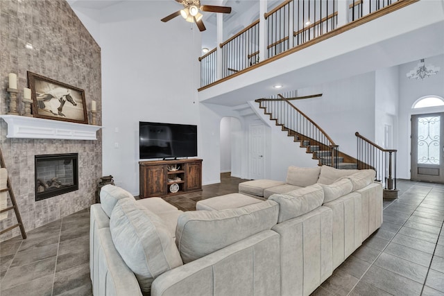 566 Long Meadow Dr, Haslet, TX 76052 - living room with a towering ceiling, stairs, a ceiling fan, a fireplace, and arched walkways