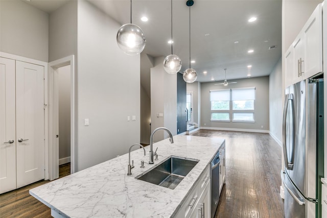3816 Roseland Ave Unit C200, Dallas, TX 75204 - kitchen with freestanding refrigerator, dark wood-style floors, white cabinets, open floor plan, and decorative light fixtures