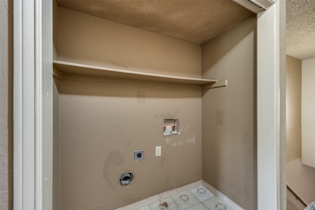 9801 Royal Ln Unit 703, Dallas, TX 75231 - laundry area featuring hookup for an electric dryer, hookup for a washing machine, marble finish flooring, a textured ceiling, and baseboards