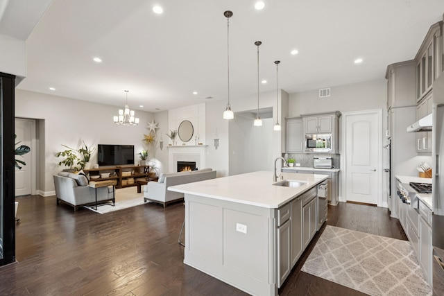 925 Glen Lake Dr, Southlake, TX 76092 - kitchen with gray cabinetry, appliances with stainless steel finishes, a lit fireplace, open floor plan, and recessed lighting