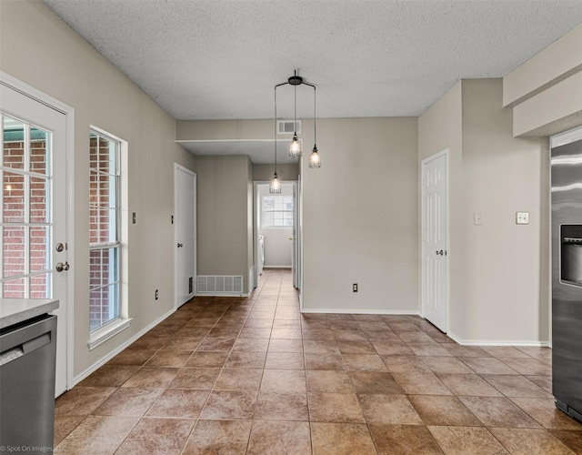 612 Yosemite Trl, Mesquite, TX 75149 - unfurnished dining area with a textured ceiling and baseboards