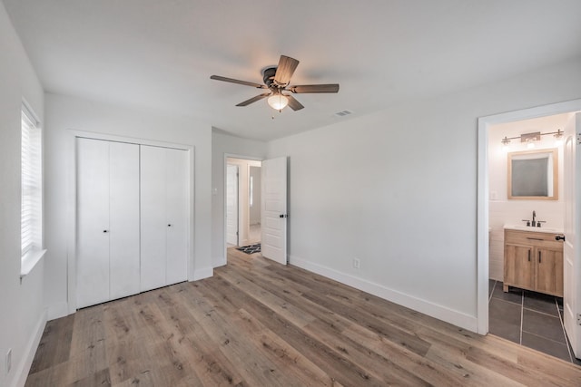 509 Twilight Dr, Garland, TX 75040 - unfurnished bedroom with a closet, wood finished floors, baseboards, a sink, and connected bathroom
