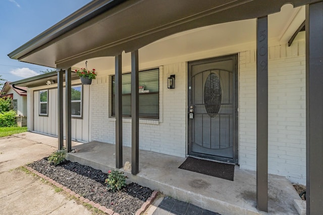 509 Twilight Dr, Garland, TX 75040 - entrance to property featuring covered porch, brick siding, and board and batten siding