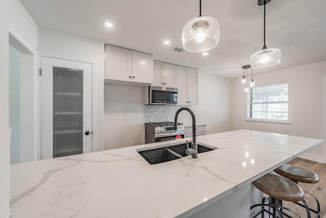 509 Twilight Dr, Garland, TX 75040 - kitchen featuring appliances with stainless steel finishes, decorative backsplash, light stone counters, white cabinets, and recessed lighting