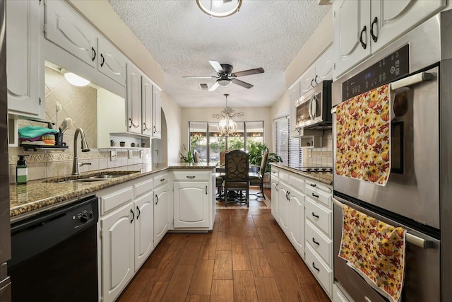 4225 Toledo Ave, Fort Worth, TX 76133 - kitchen with appliances with stainless steel finishes, a sink, a peninsula, white cabinetry, and a textured ceiling