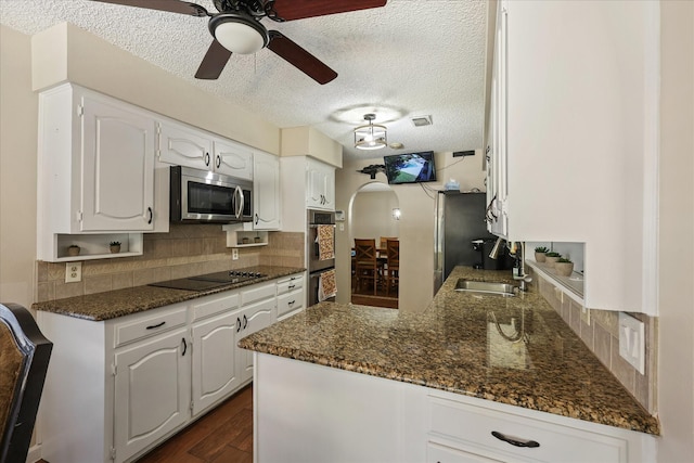 4225 Toledo Ave, Fort Worth, TX 76133 - kitchen featuring appliances with stainless steel finishes, white cabinets, tasteful backsplash, ceiling fan, and dark wood-type flooring