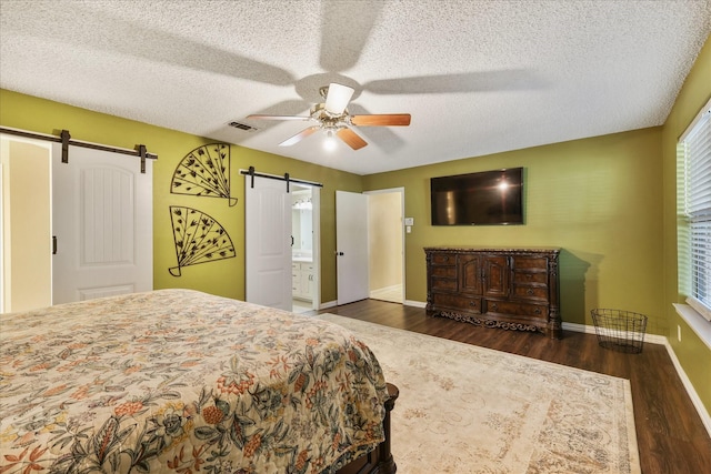 4225 Toledo Ave, Fort Worth, TX 76133 - bedroom with a barn door, wood finished floors, baseboards, a ceiling fan, and a textured ceiling