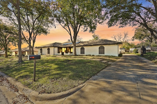 4225 Toledo Ave, Fort Worth, TX 76133 - view of front of home featuring driveway, roof mounted solar panels, a front yard, and brick siding