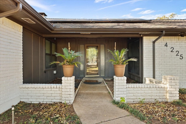 4225 Toledo Ave, Fort Worth, TX 76133 - entrance to property featuring roof mounted solar panels, brick siding, and roof with shingles