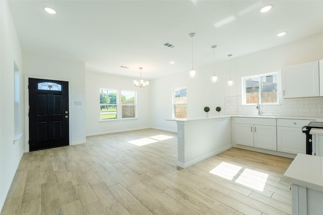 4709 Lee St, Greenville, TX 75401 - kitchen with a chandelier, a peninsula, backsplash, light countertops, and a sink