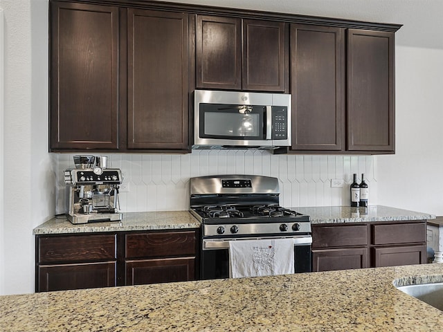 2624 Rambling Rd, Celina, TX 75009 - kitchen with stainless steel appliances, tasteful backsplash, and dark brown cabinets