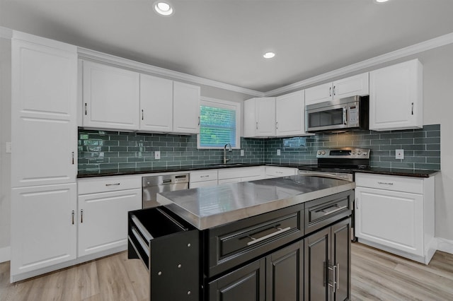 1229 Kiowa Dr E, Lake Kiowa, TX 76240 - kitchen featuring appliances with stainless steel finishes, light wood finished floors, white cabinetry, dark countertops, and crown molding