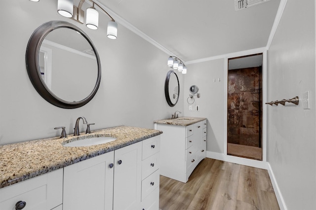 1229 Kiowa Dr E, Lake Kiowa, TX 76240 - bathroom with two vanities, wood finished floors, tiled shower, crown molding, and baseboards
