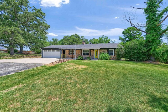 1229 Kiowa Dr E, Lake Kiowa, TX 76240 - single story home featuring an attached garage, driveway, a chimney, brick siding, and a front yard