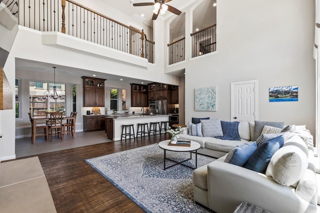 4548 Pecan Valley Dr, Plano, TX 75093 - living room with dark wood finished floors, a ceiling fan, a towering ceiling, a chandelier, and baseboards