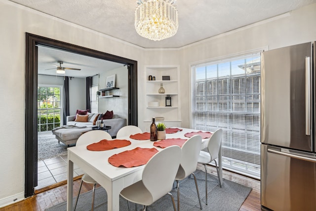 2435 W 10th St, Dallas, TX 75211 - dining area featuring built in shelves, a textured ceiling, wood finished floors, a chandelier, and crown molding