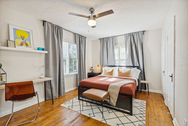 2435 W 10th St, Dallas, TX 75211 - bedroom featuring hardwood / wood-style floors, a textured ceiling, baseboards, a desk, and a ceiling fan