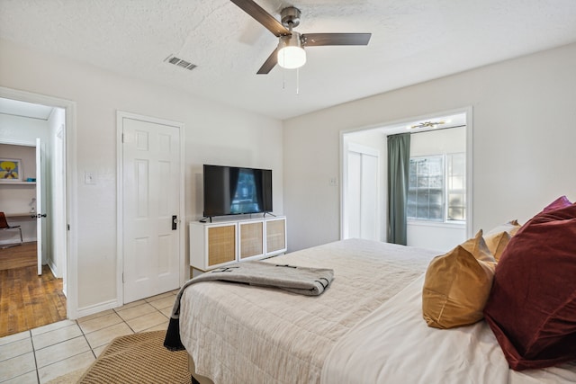 2435 W 10th St, Dallas, TX 75211 - bedroom featuring light tile patterned flooring, ceiling fan, and baseboards