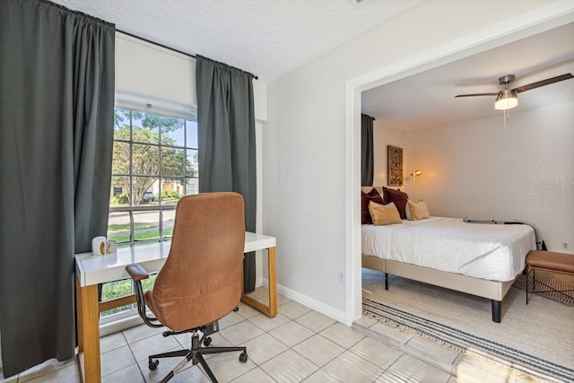 2435 W 10th St, Dallas, TX 75211 - bedroom featuring light tile patterned floors, baseboards, a textured ceiling, and ceiling fan