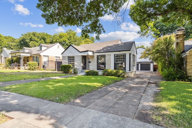 2435 W 10th St, Dallas, TX 75211 - view of front of property featuring an outbuilding, stone siding, a garage, and a front lawn