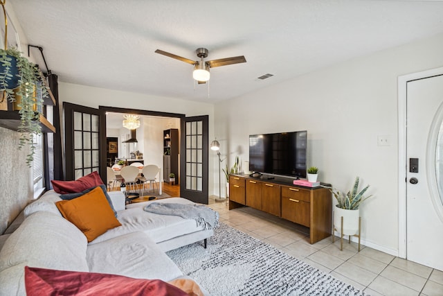 2435 W 10th St, Dallas, TX 75211 - living room with light tile patterned floors, baseboards, ceiling fan, a chandelier, and french doors