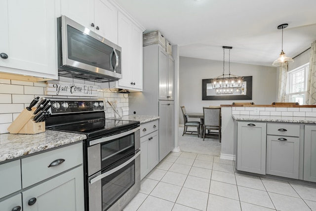 806 Twin View St, Heath, TX 75032 - kitchen with stainless steel appliances, gray cabinetry, decorative backsplash, a chandelier, and pendant lighting