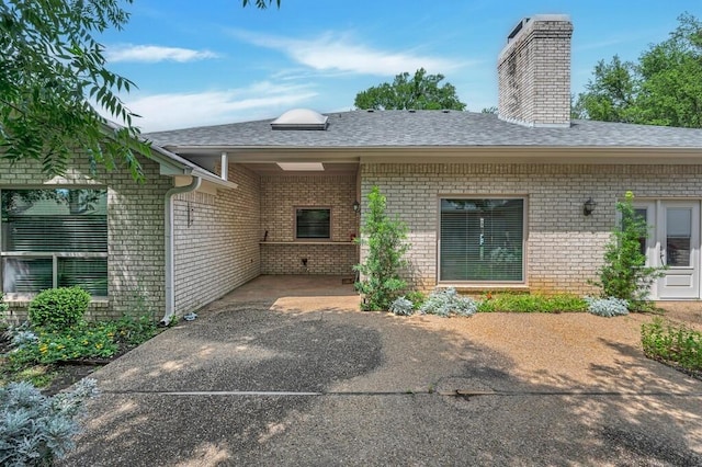 3009 Chimney Hill Dr, Waco, TX 76708 - doorway to property featuring brick siding, roof with shingles, and a chimney