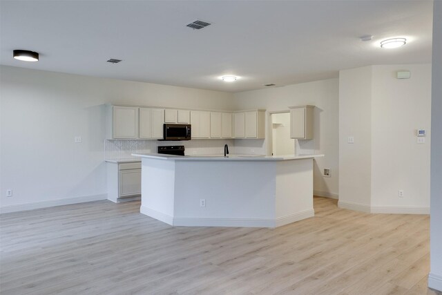 3037 Elmbrook Dr, Grand Prairie, TX 75052 - kitchen with stainless steel microwave, light wood finished floors, baseboards, a sink, and light countertops