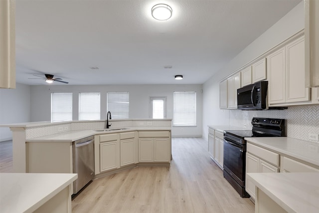 3037 Elmbrook Dr, Grand Prairie, TX 75052 - kitchen featuring black appliances, a sink, light wood-style flooring, and backsplash