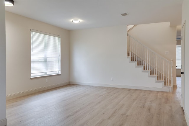 3037 Elmbrook Dr, Grand Prairie, TX 75052 - empty room with light wood-type flooring, stairway, and baseboards