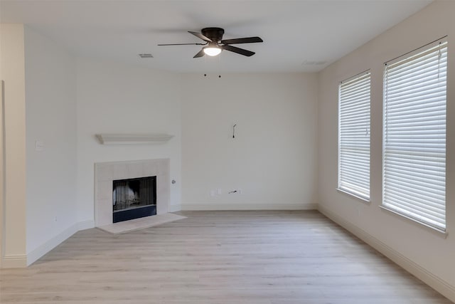 3037 Elmbrook Dr, Grand Prairie, TX 75052 - unfurnished living room with light wood-type flooring, plenty of natural light, a ceiling fan, and a tile fireplace