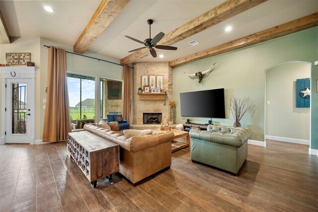 134 Southern Ct, Springtown, TX 76082 - living room featuring a ceiling fan, wood finished floors, a fireplace, arched walkways, and beam ceiling