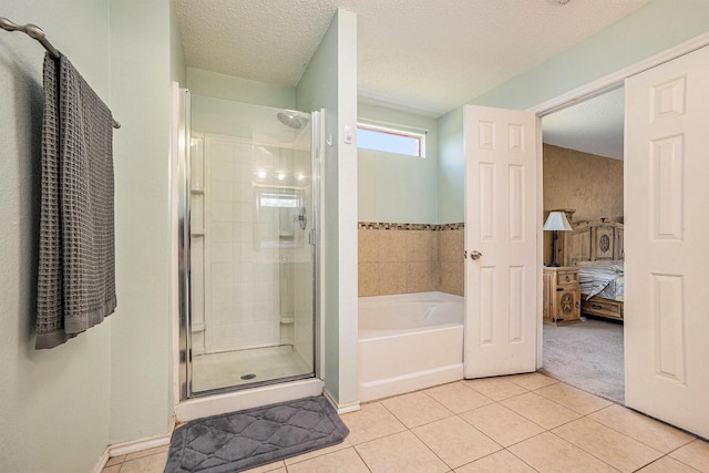 1400 Sunflower Ct, Burleson, TX 76028 - ensuite bathroom featuring tile patterned flooring, a bath, a stall shower, and a textured ceiling
