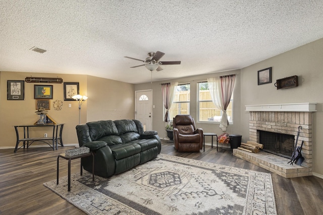 1400 Sunflower Ct, Burleson, TX 76028 - living room featuring ceiling fan, dark wood-type flooring, a textured ceiling, a brick fireplace, and baseboards