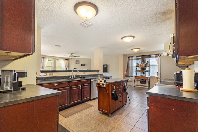 1400 Sunflower Ct, Burleson, TX 76028 - kitchen with a sink, dark countertops, stainless steel dishwasher, a textured ceiling, and light tile patterned flooring