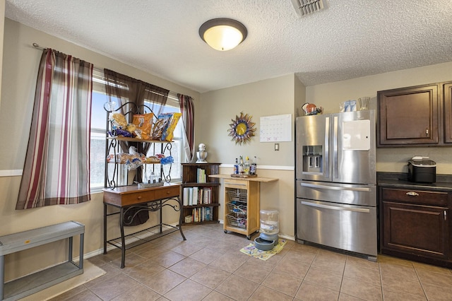 1400 Sunflower Ct, Burleson, TX 76028 - kitchen featuring stainless steel fridge, a textured ceiling, light tile patterned floors, and dark brown cabinets