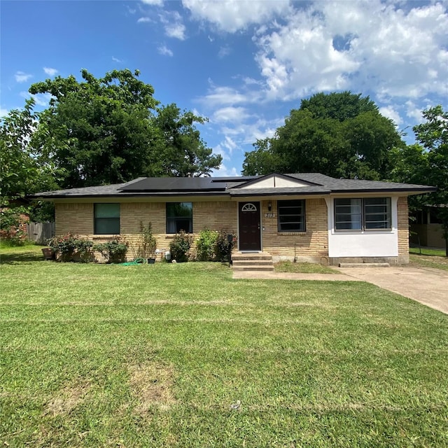 313 Wall St, Terrell, TX 75160 - ranch-style house featuring a front yard, brick siding, and solar panels