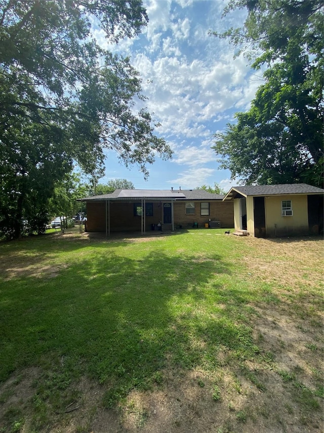 313 Wall St, Terrell, TX 75160 - rear view of property with a yard and an outdoor structure