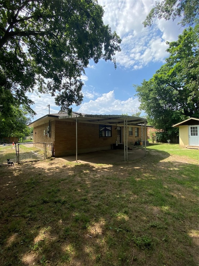 313 Wall St, Terrell, TX 75160 - back of house featuring a gate, brick siding, and an attached carport