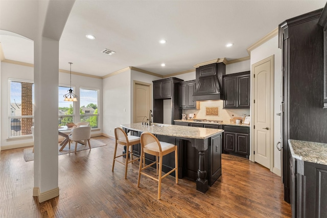 647 Gillon Way, Rockwall, TX 75087 - kitchen with ornamental molding, baseboards, a center island with sink, arched walkways, and recessed lighting