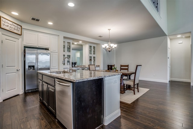 1137 Olympic Dr, Celina, TX 75009 - kitchen with stainless steel fridge with ice dispenser, light stone counters, a sink, dark wood-type flooring, and a chandelier
