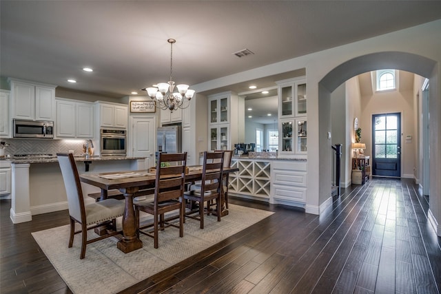 1137 Olympic Dr, Celina, TX 75009 - dining area featuring arched walkways, a chandelier, dark wood-style floors, recessed lighting, and baseboards
