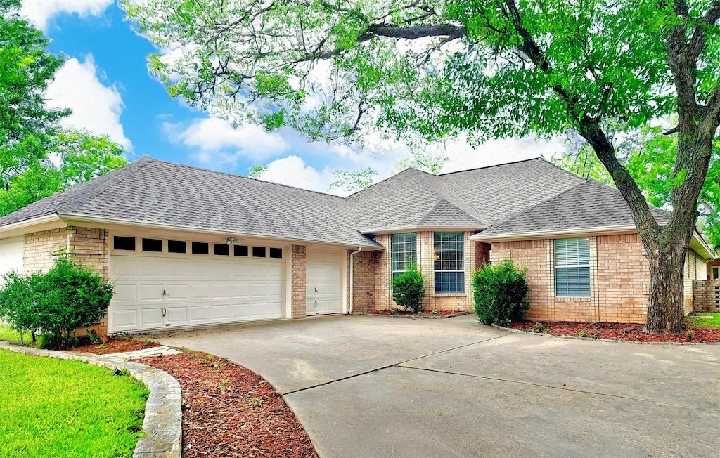 5522 Wedgefield Rd, Granbury, TX 76049 - view of front facade featuring brick siding, an attached garage, concrete driveway, and roof with shingles
