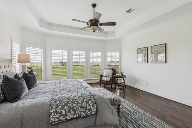 3076 W Alamosa Dr, Terrell, TX 75160 - bedroom with multiple windows, wood finished floors, a tray ceiling, ornamental molding, and baseboards