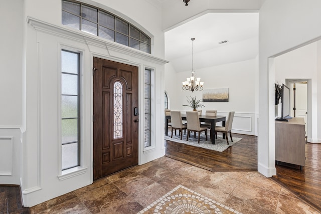3076 W Alamosa Dr, Terrell, TX 75160 - foyer entrance with a high ceiling, a decorative wall, a chandelier, a wainscoted wall, and stone finish floors